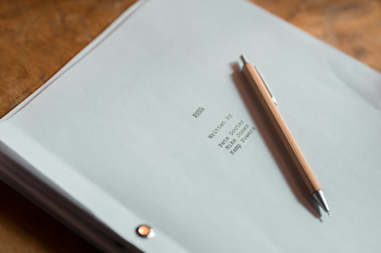 Close-up of a film script titled Soul next to a pen on a wooden desk.