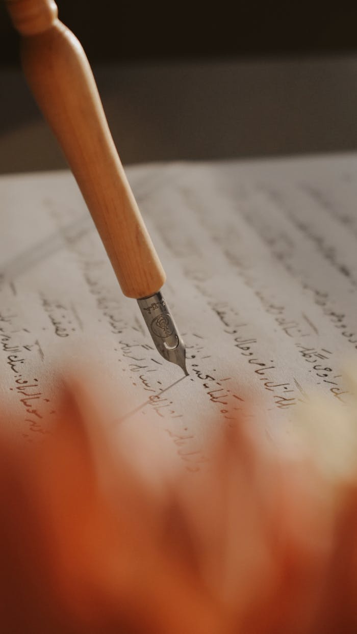 Close-up of vintage fountain pen writing elegant calligraphy on paper.